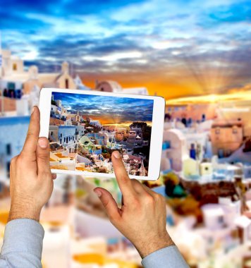 Santorini Adası Oia şehirdeki dokunmatik yüzey ile turist adam alarak resim. 