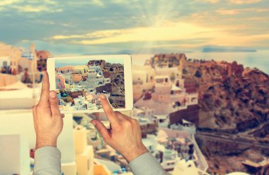 Santorini Adası Oia şehirdeki dokunmatik yüzey ile turist adam alarak resim. 