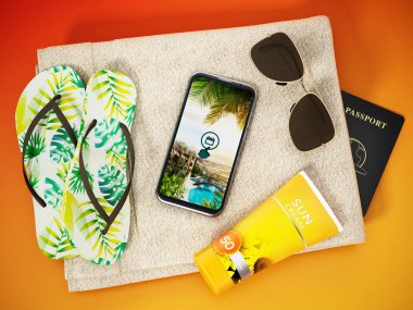 Terlikler, güneş kremi tüpü, akıllı telefon ve plaj havlusunda duran güneş gözlüğü. 3d illüstrasyon