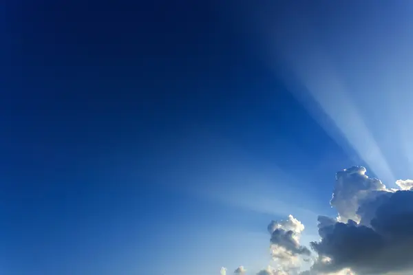 Lichtstrahlen explodieren bei klarem blauem Himmel mit Wolken — Stockfoto