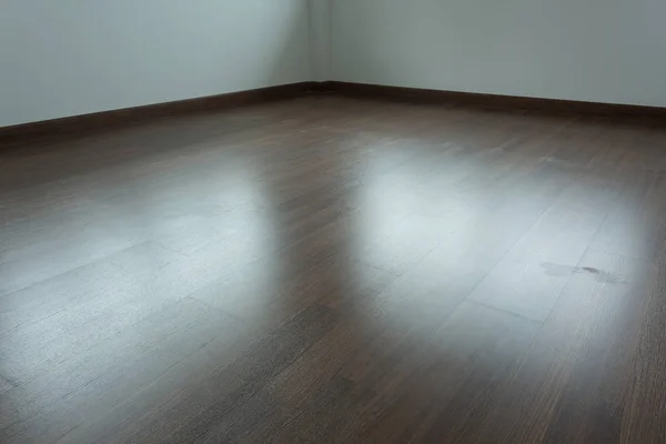 Empty room interior, brown wood laminate floor and white mortar — Stock Photo, Image