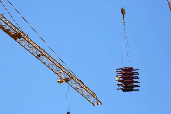 Maschinenkran hievt Stahlstange in Baustelle — Stockfoto