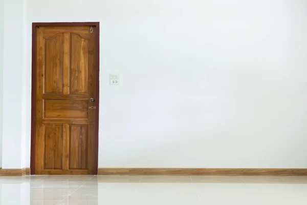 Prázdný prostor interiér s dřevěnými dveřmi a bílou omítkou zeď — Stock fotografie