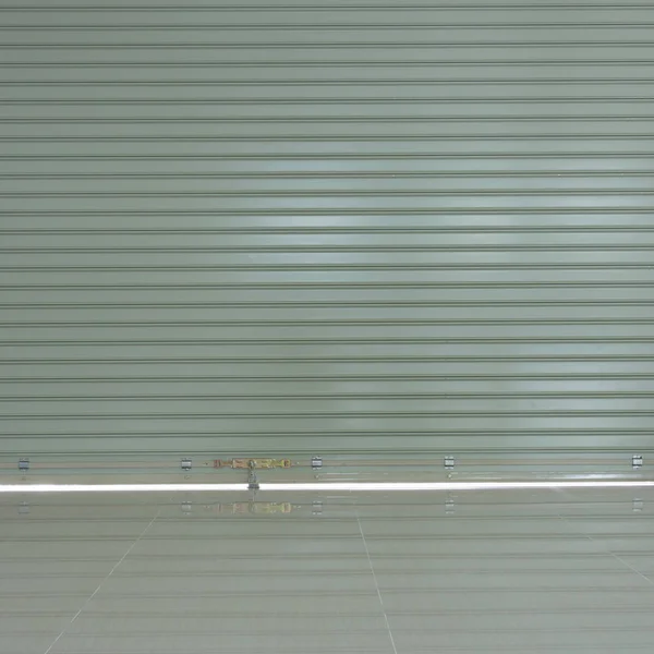 Puerta de persiana de acero de aluminio y piso de baldosas en almacén — Foto de Stock