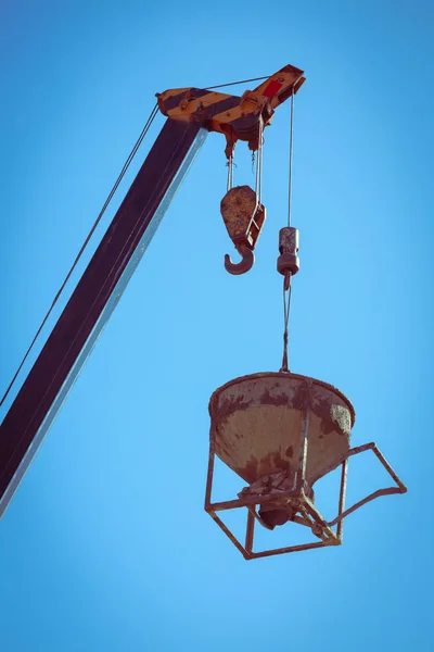 Machinery crane hoisting cement mortar mixer bucket — Stock Photo, Image