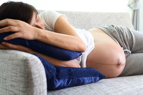 Wanita hamil tidur di sofa furnitur di ruang tamu — Stok Foto