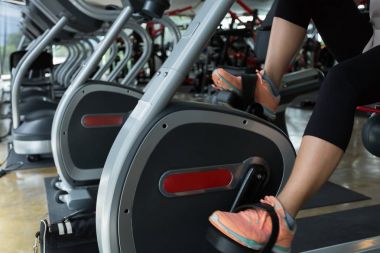 kadın fitness salonunda Bisiklet kardiyo makinede yağ yakmak Bisiklete binme 