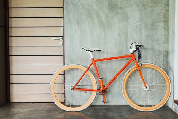 Bicicleta laranja estacionada decorar interior sala de estar estilo moderno — Fotografia de Stock