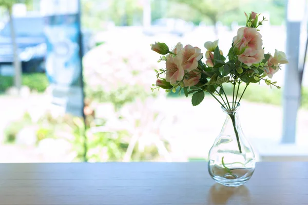 Красивый искусственный цветок в маленькой стеклянной вазе — стоковое фото