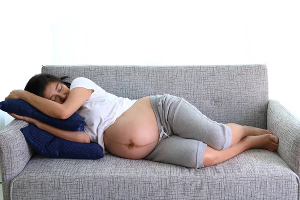 女人怀孕睡在客厅里的沙发家具 — 图库照片