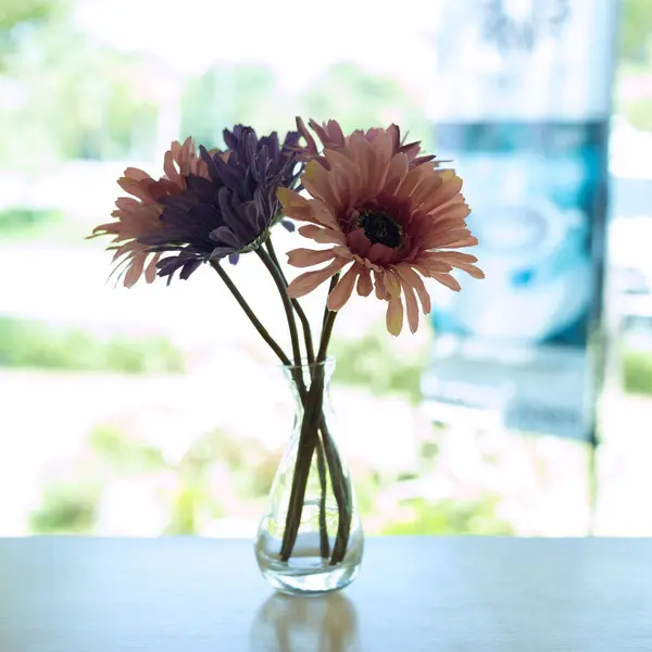 Bela flor artificial em vaso de vidro pequeno colocar em madeira — Fotografia de Stock