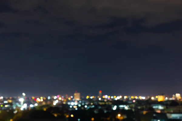 Cidade noite com céu escuro, abstrato borrão bokeh luz de fundo — Fotografia de Stock