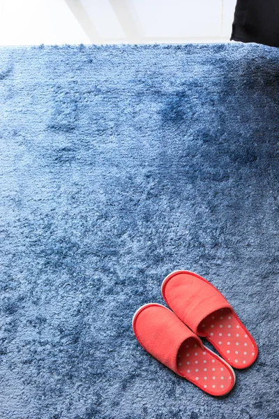 Sapato de chinelo vermelho no tapete azul tapete chão maciez — Fotografia de Stock