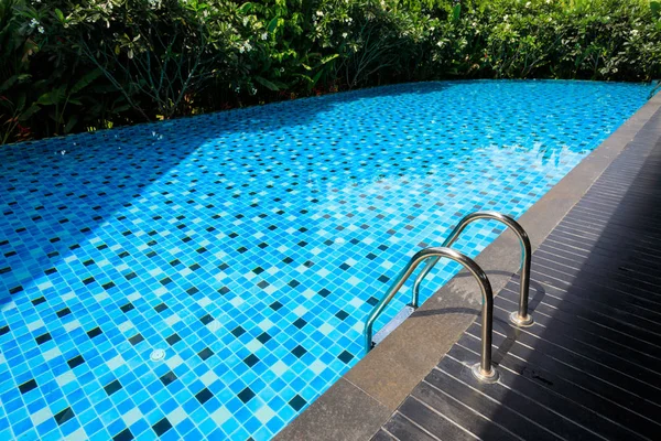 Piscine bleue autour avec jardin naturel verdoyant — Photo