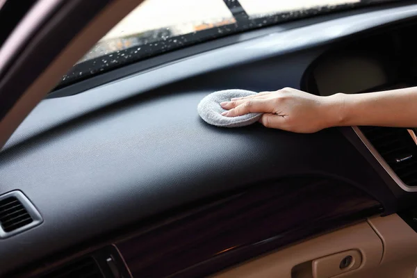 Ženská ruka čištění kožené černé konzoly v autě — Stock fotografie