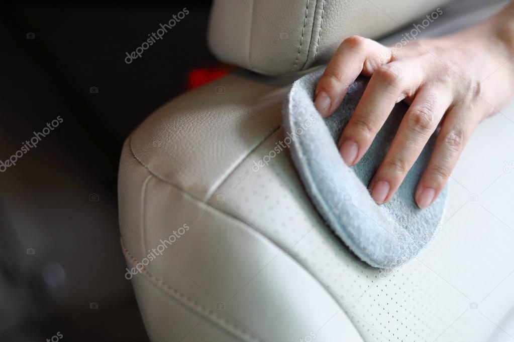 woman hand cleaning leather seat in car