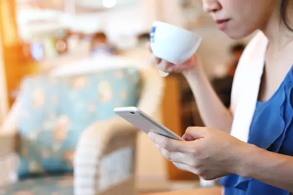 Vrouw met behulp van internet mobiele telefoontechnologie in café koffie — Stockfoto