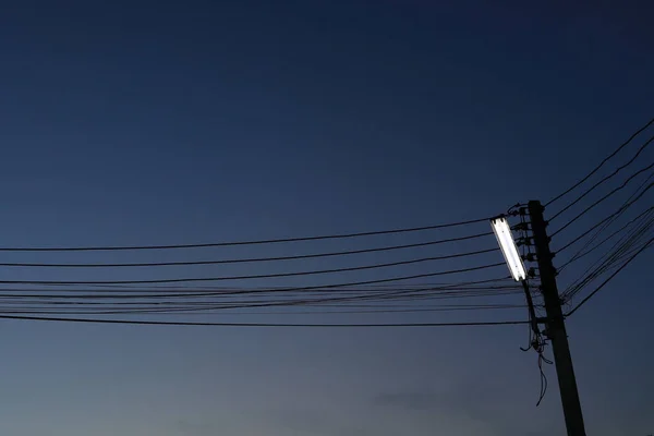 Straat lamp op elektriciteit post met donkere nachtelijke hemel — Stockfoto