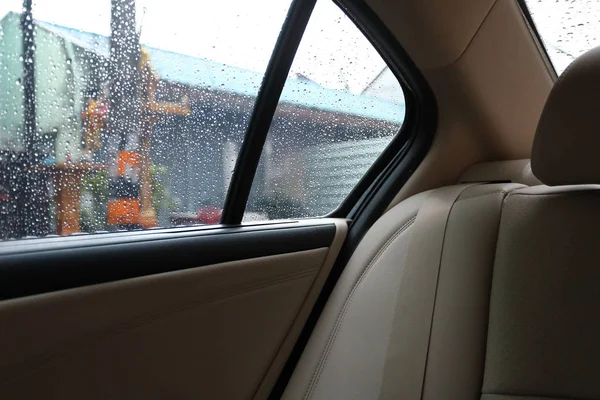 Kursi belakang di dalam mobil kendaraan dengan curah hujan di jendela — Stok Foto