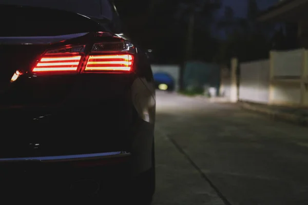 Красный задний фонарь современного спортивного автомобиля на ночной улице — стоковое фото