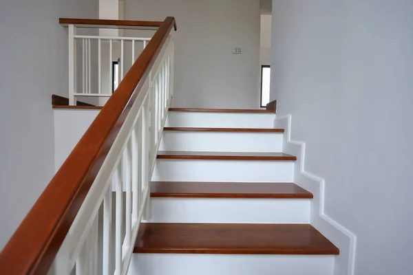 Escada de madeira marrom com balaustrada de aço branco e corrimão de madeira dura corrimão na casa residencial moderna — Fotografia de Stock