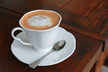 Sıcak kahve içeceği sabah tahta masa kahvaltısına konur.