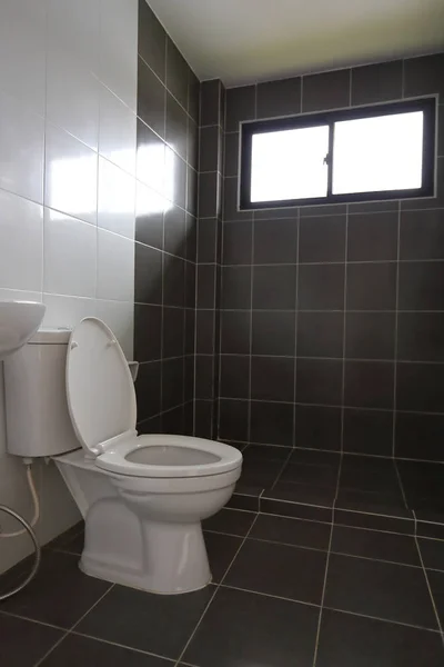 Diseño moderno de pequeño cuarto de baño con baño blanco armario de agua y utiliza pared de baldosas negras y suelo —  Fotos de Stock