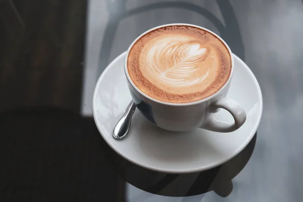 Bebida caliente de café con leche puesta en la mesa en la cafetería — Foto de Stock