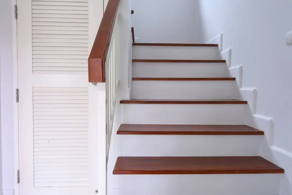 Escada de madeira marrom e parede branca na casa residencial — Fotografia de Stock