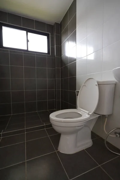 Design moderne de petite salle de bains avec placard d'eau de toilettes blanches et utilisé mur de tuiles noires et le sol — Photo