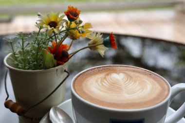 Kahve masasında sıcak latte içeceği var.