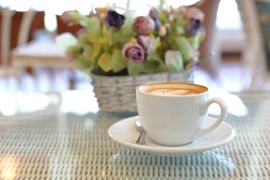 Kafe restoranındaki beyaz masaya bir fincan sıcak kahve.