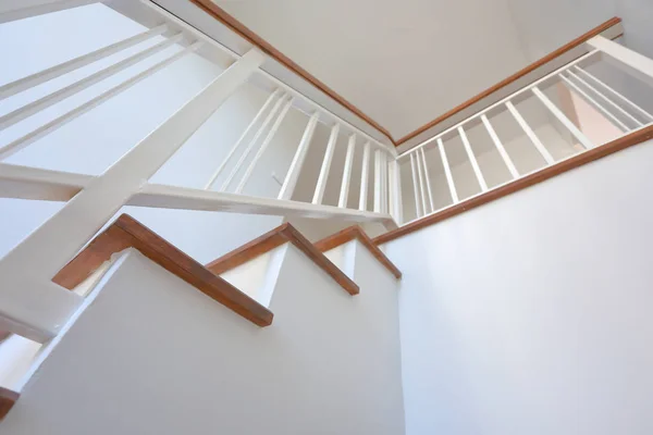 Hnědé dřevěné schodiště s bílou ocelovou balustrádou a zábradlím z tvrdého dřeva v moderním obytném domě — Stock fotografie