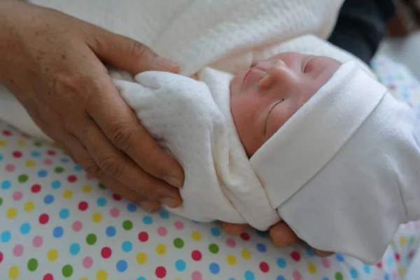 Nonna vecchia mano che tiene il bambino carino neonato di nipote con amore — Foto Stock