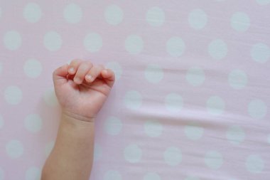 Pembe arka planda küçük bir bebek eli