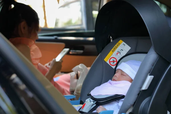 Bayi lucu tidur di kursi mobil keselamatan drive dengan ibu, perjalanan keluarga yang bahagia di hari liburan — Stok Foto