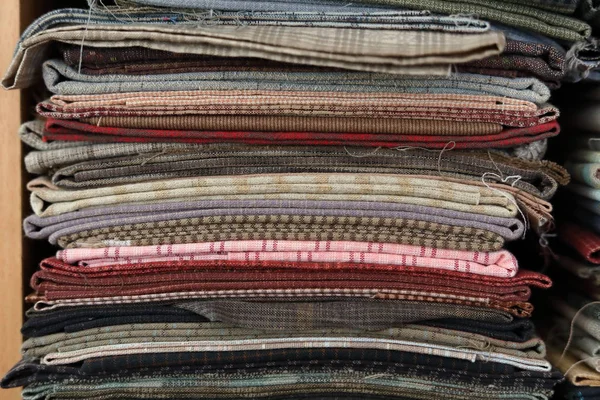 Stapel bitar tyg många mönster på hylla, material återvinning för kläder mode design — Stockfoto