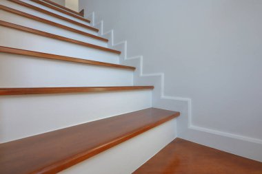 Kahverengi ahşap merdiven ve beyaz duvar.