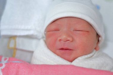 Tatlı, yeni doğmuş bebek yumuşak bir battaniyeyle tatlı bir rüyada uyuyor.
