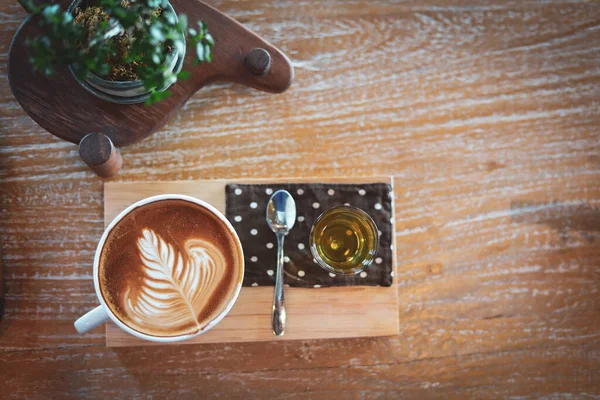 Hot latte coffee drink put on wooden table in cafe restaurant — Stock Photo, Image