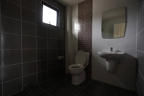 Design moderne de petite salle de bains avec placard d'eau de toilettes blanches et utilisé mur de tuiles noires et le sol — Photo