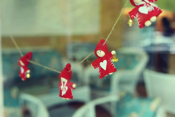Маленькая рождественская кукла висит украшение на стеклянном окне — стоковое фото