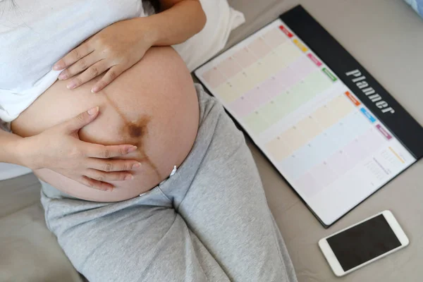 Moeder zwanger moederschap met behulp van planner schema — Stockfoto