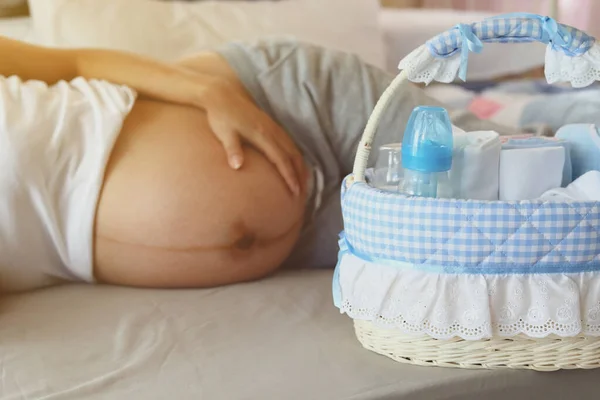 Mãe nova maternidade preparando fralda e mamadeira de leite na cesta para um bebê recém-nascido em família com amor — Fotografia de Stock