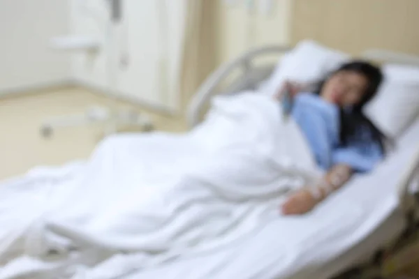 Unschärfe des Bildes einer Patientin, die im Aufwachraum des Krankenhauses auf dem Bett liegt — Stockfoto