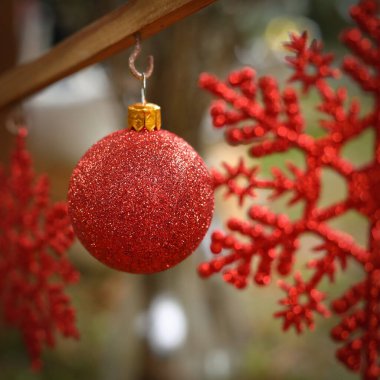 Kırmızı noel balosu süsü açık bahçede asılı duruyor.