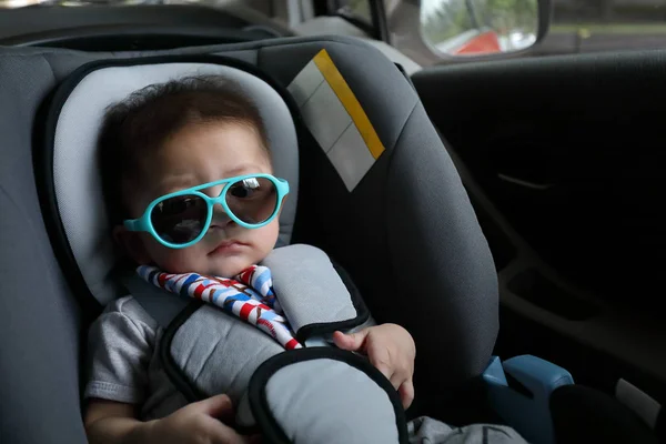 Lindo bebé niño sentado en el asiento de seguridad del coche cinturón de seguridad de protección para conducir viaje por carretera en el día de verano — Foto de Stock