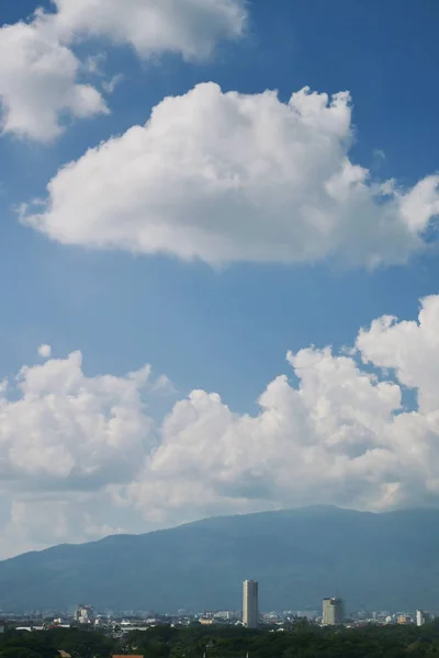 Белое облако на ясном голубом небе над городом — стоковое фото