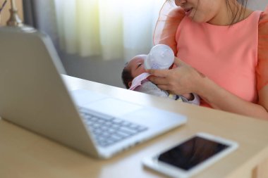 İş kadını, iş yerindeki küçük oğluna ebeveynlik yapıyor.