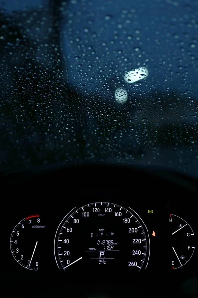 Luce notturna del tachimetro nell'automobile moderna del veicolo con caduta di pioggia sul finestrino — Foto Stock